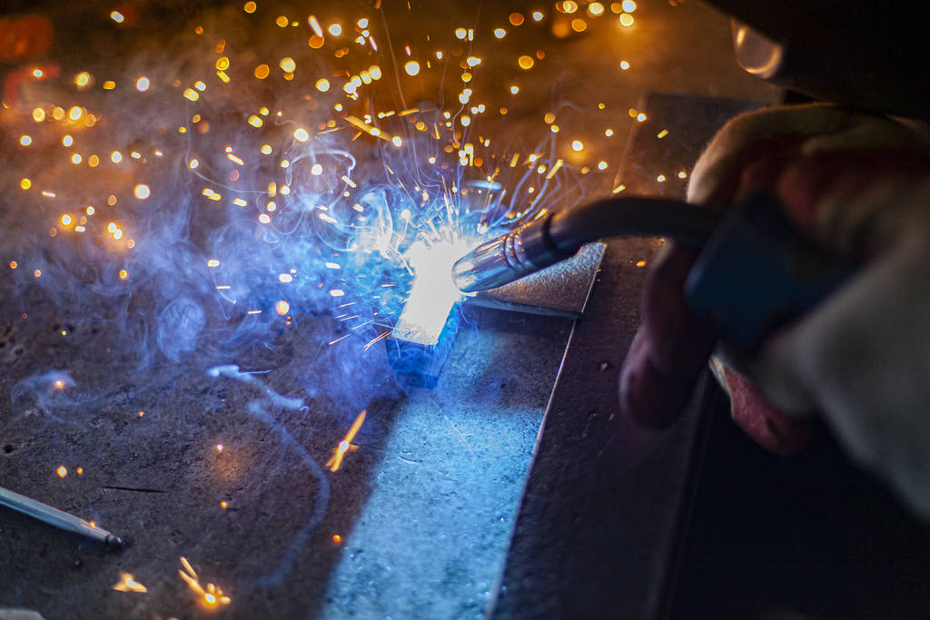 Metal welding. Sparks from electric heating. Work in the workshop. Creation of reliable fastening of materials. Fabrication of iron. The work of the master of metal. - 写真・画像