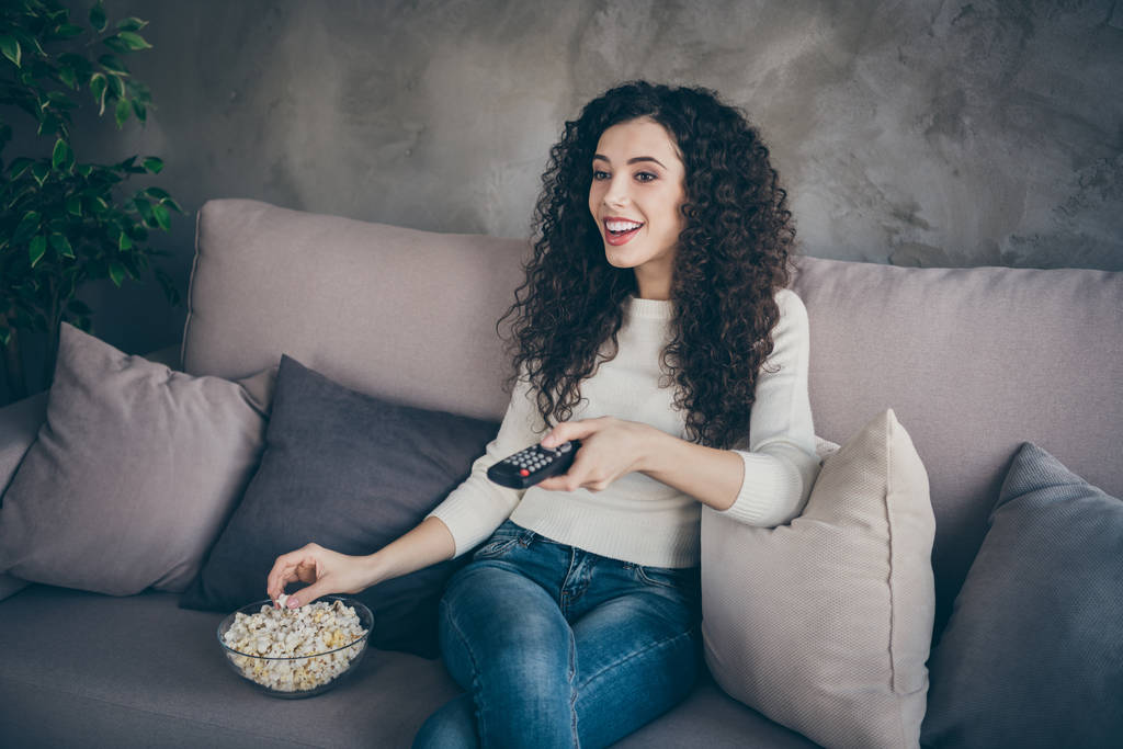 Portrait of her she nice attractive charming lovely cheerful cheery peaceful wavy-haired girl sitting on divan watching tv show at modern industrial loft interior style room - Photo, Image