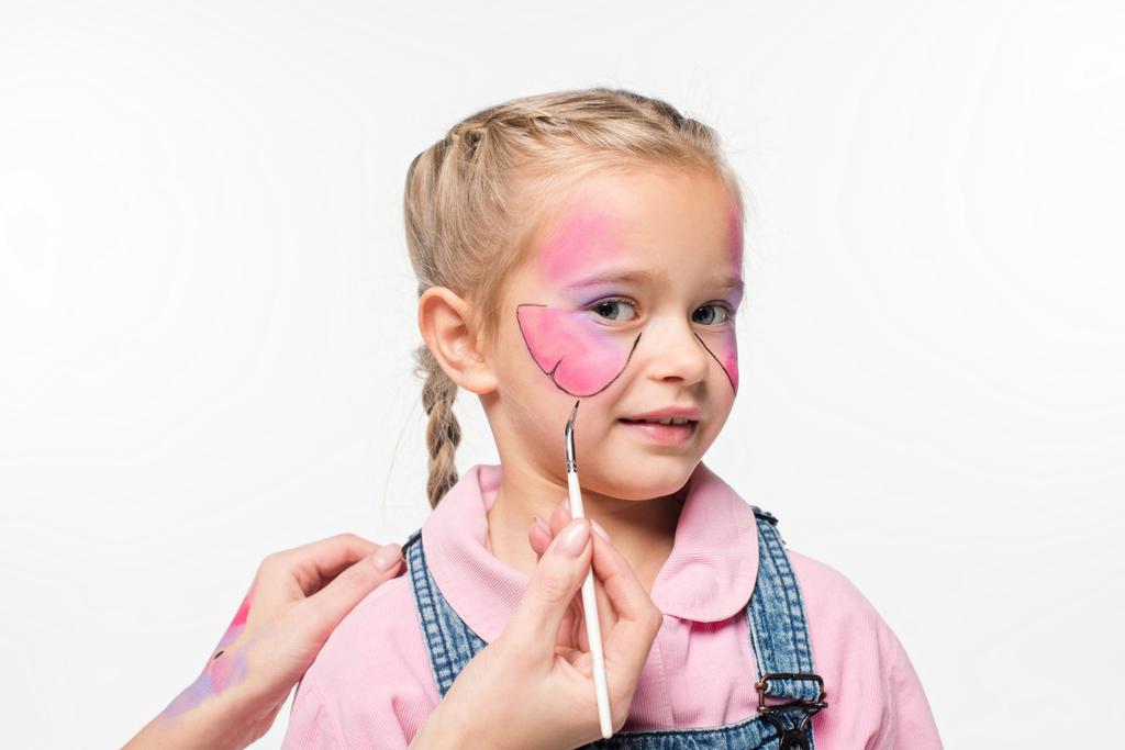 μερική άποψη του καλλιτέχνη πεταλούδα ζωγραφική στο πρόσωπο του αξιολάτρευτο παιδί που απομονώνονται σε λευκό - Φωτογραφία, εικόνα