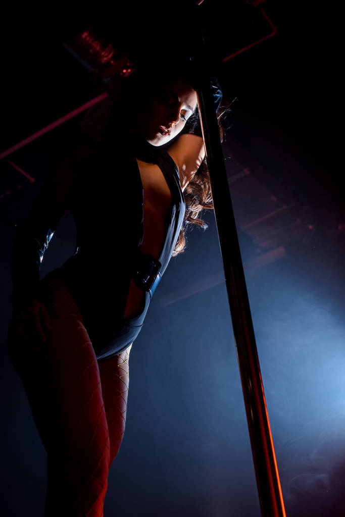 низький кут зору сексуальної жінки полюс танцює на чорному
  - Фото, зображення