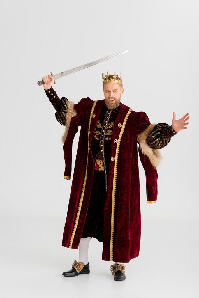 rozzlobený král s korunou drží meč izolovaný na šedi - Fotografie, Obrázek