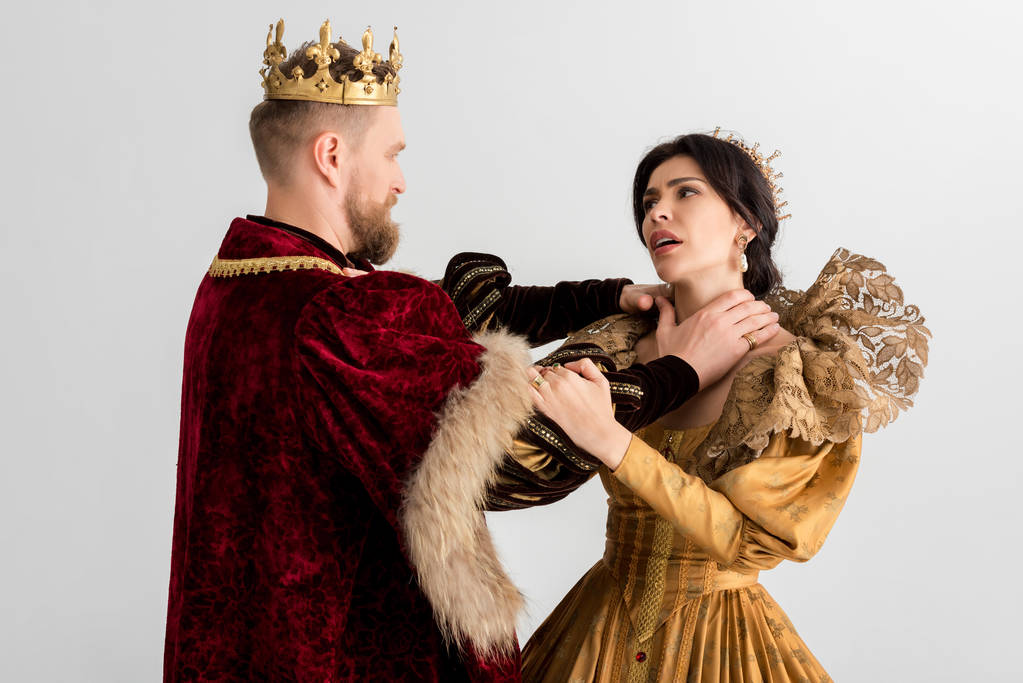 König mit Krone würgt attraktive Königin isoliert auf grau - Foto, Bild