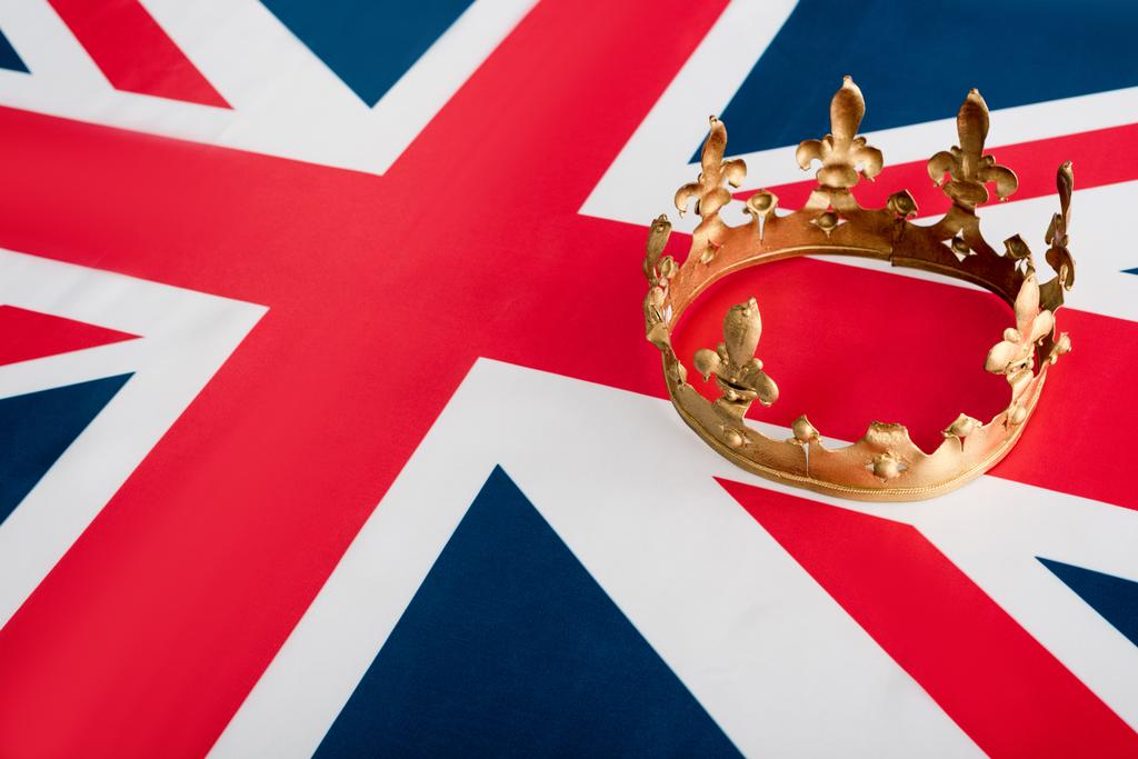 hoge hoek uitzicht van gouden kroon op Britse vlag  - Foto, afbeelding