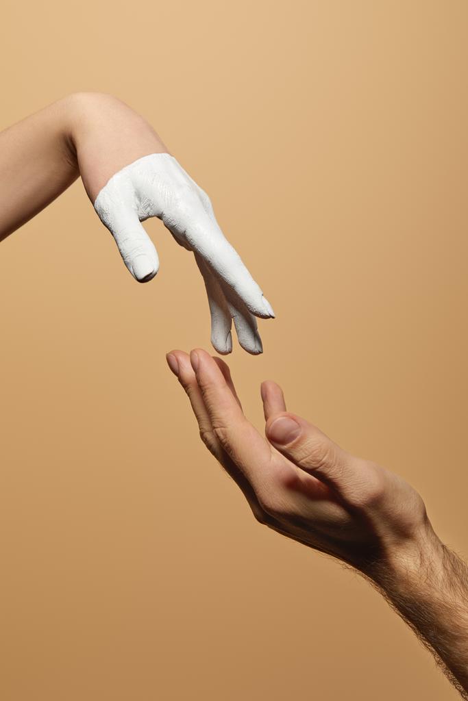 обрізаний вид чоловіка і жінки з пофарбованою рукою торкається один одного ізольовано на бежевому
 - Фото, зображення