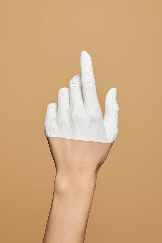 abgeschnittene Ansicht einer Frau mit weiß bemalter Hand isoliert auf beige - Foto, Bild