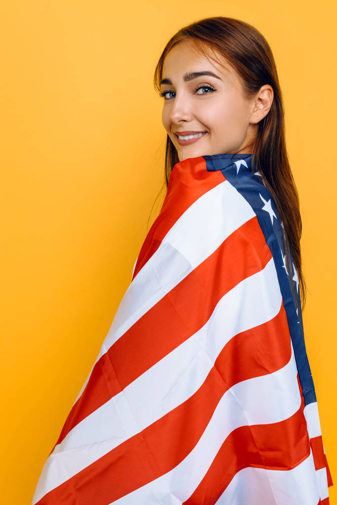 Nuori kaunis tyttö valkoisessa t-paidassa Amerikan lipun kanssa
,  - Valokuva, kuva