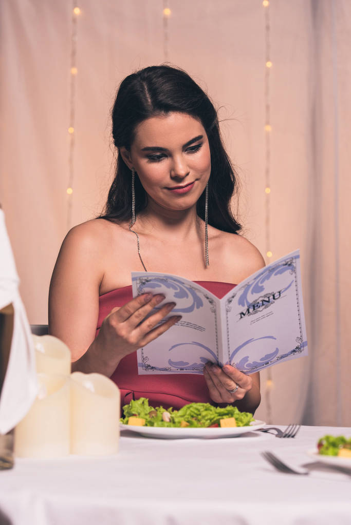 atractivo, elegante chica de menú de lectura mientras está sentado en el restaurante
 - Foto, imagen