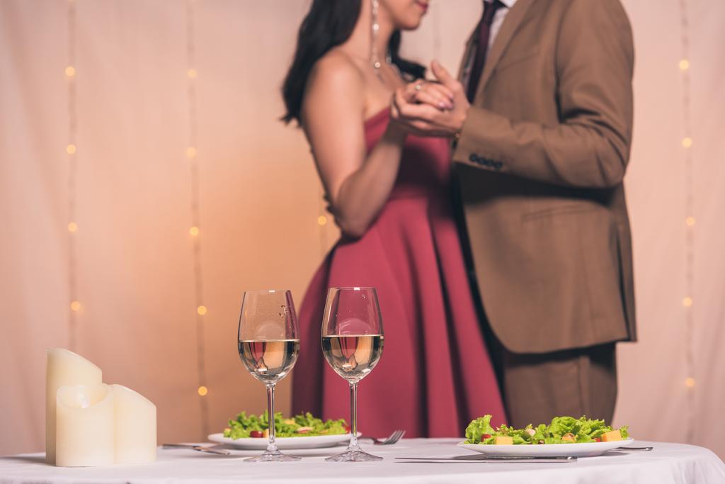 Yemek masasının yanındaki restoranda dans eden zarif erkek ve kadın manzarası. - Fotoğraf, Görsel