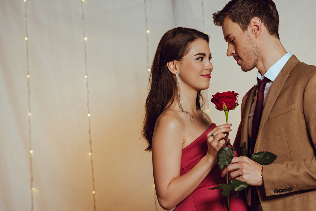 Красивый, элегантный мужчина представляет красную розу красивой девушке в ресторане
 - Фото, изображение