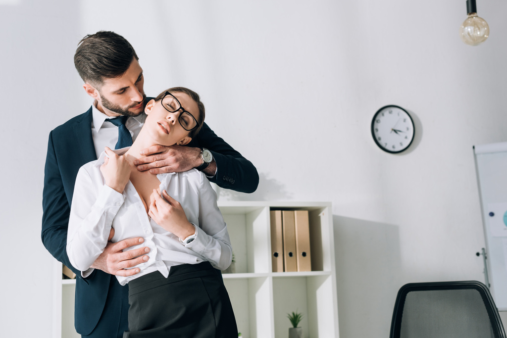 jóképű üzletember ölelés szexi titkárnő csukott szemmel az irodában  - Fotó, kép