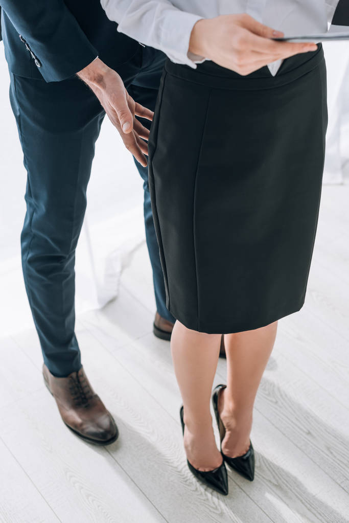 cropped view of businessman touching butt of secretary in office  - 写真・画像