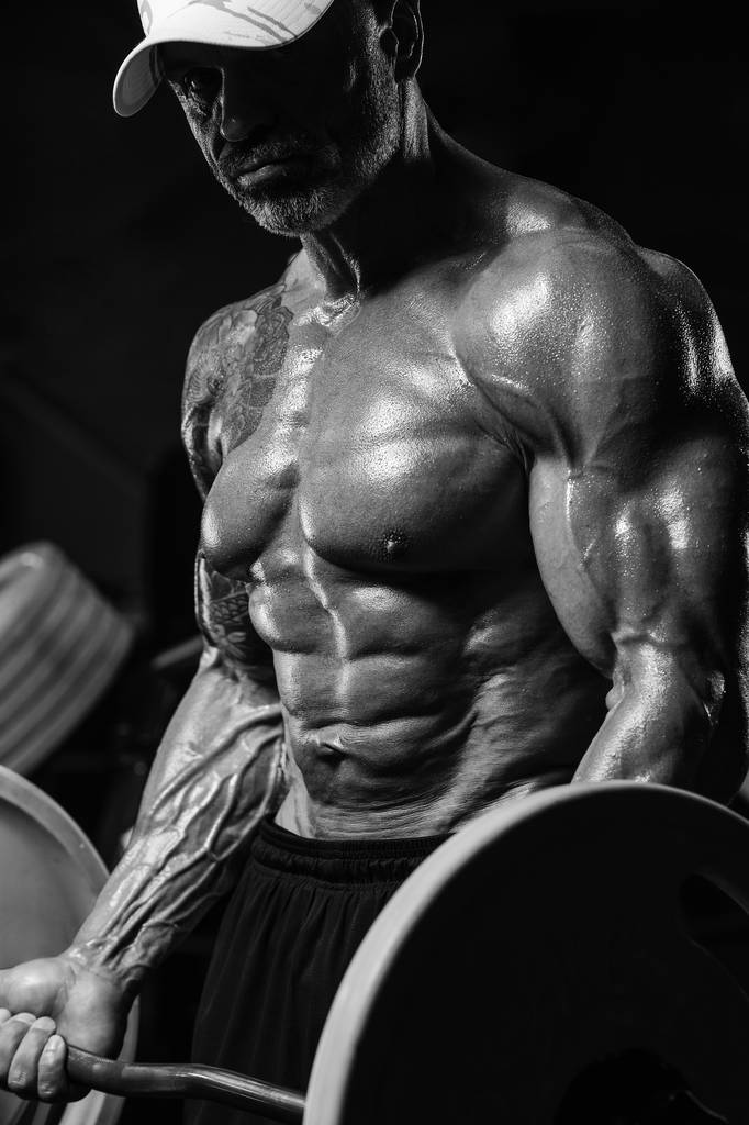 Csinos erős sportos férfi szivattyúzás akár bicepsz izmok edzés f - Fotó, kép