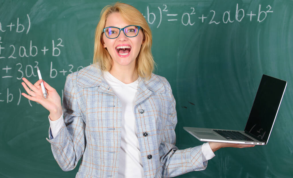 Žena učitel nosí brýle drží notebook surfování na internetu. Koncept digitálních technologií. Vzdělávač veselá dáma s moderním notebookem surfování na internetu Chalkboard pozadí. Vzdělání je zábava - Fotografie, Obrázek