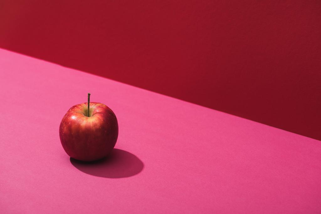 manzana jugosa fresca sobre fondo rojo y rosa
 - Foto, imagen