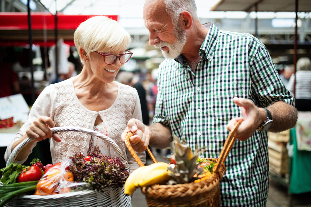 Seniorenpaar kauft Gemüse und Obst auf dem Markt ein. Gesunde Ernährung. - Foto, Bild