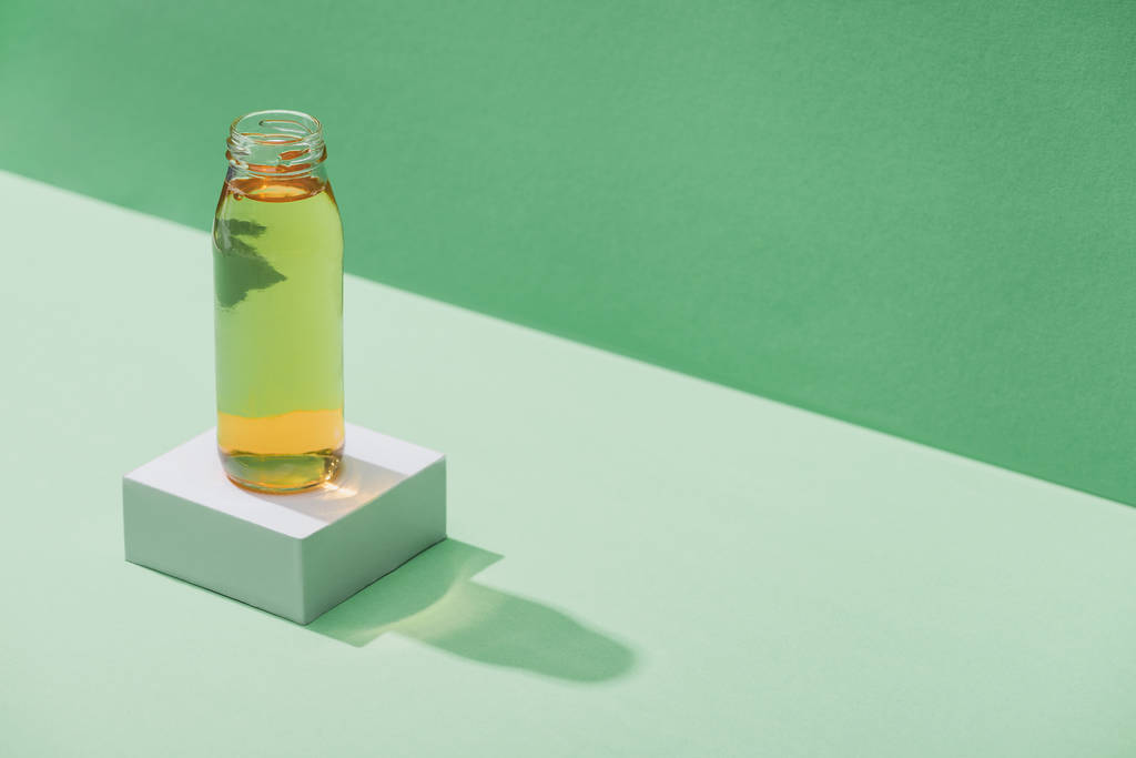 свежий яблочный сок на белом кубе на зеленом и бирюзовом фоне
 - Фото, изображение