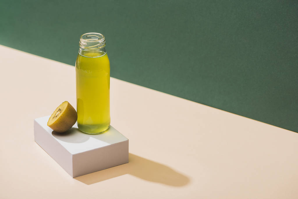 fresh juice near kiwi and and white cube on green and white background - Photo, Image