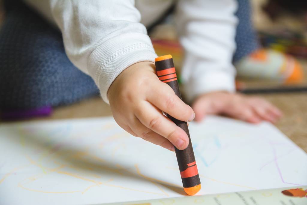 Dibujo del bebé con un lápiz naranja en el papel - Foto, imagen