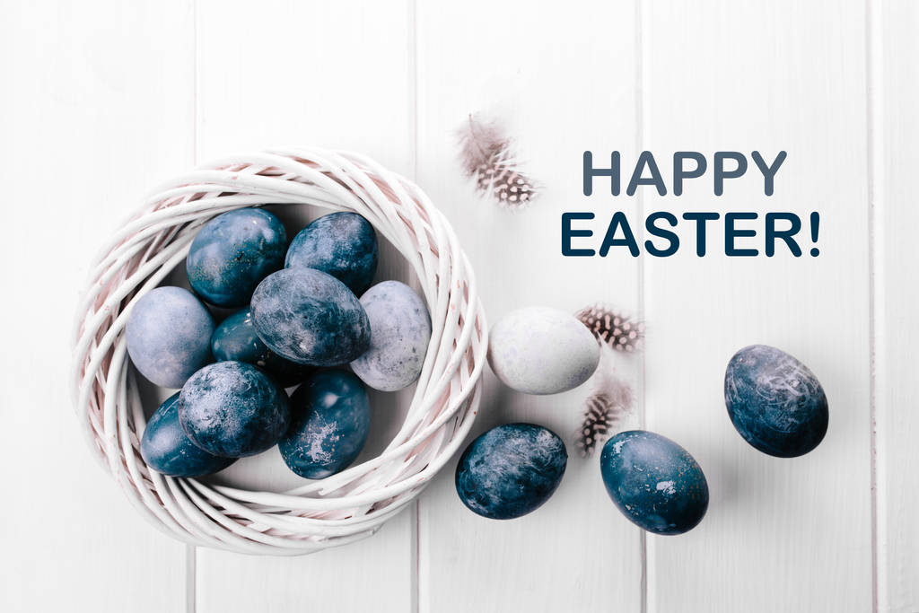 Grupo de huevos de color azul claro en su nido sobre un fondo de madera blanca. Feliz decoración de Pascua. Clásico color azul del año 2020
. - Foto, imagen