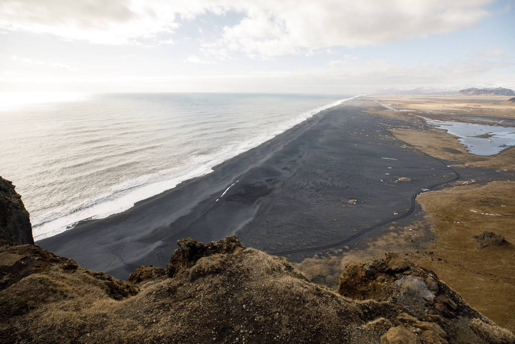 prachtig vogelzicht op bergklif en zwart zand IJsland strand  - Foto, afbeelding