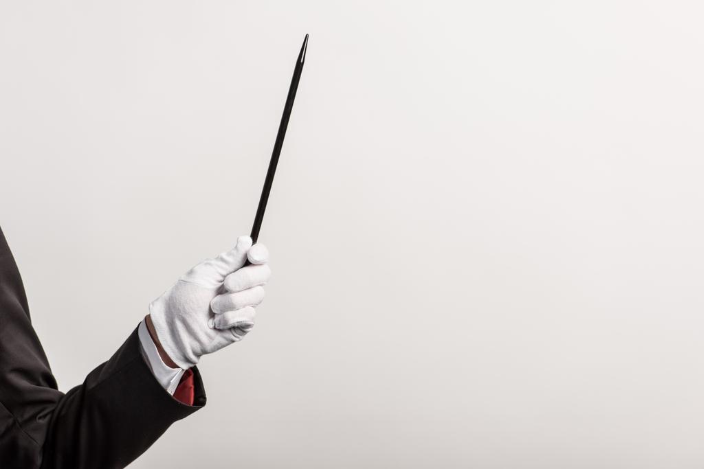 partial view of magician in glove holding wand, isolated on grey - Photo, Image