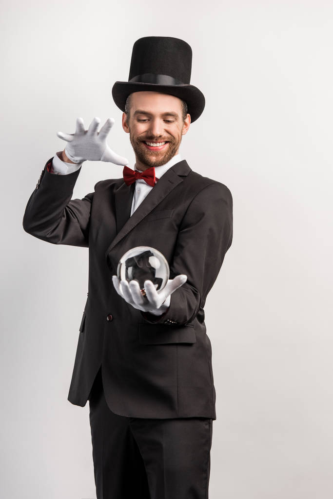 felice mago professionista in possesso di palla magica, isolato su grigio
 - Foto, immagini