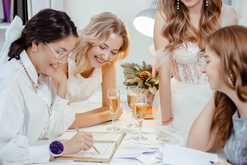 nevěsty a návrhářka klientů ve svatebním salonu - Fotografie, Obrázek