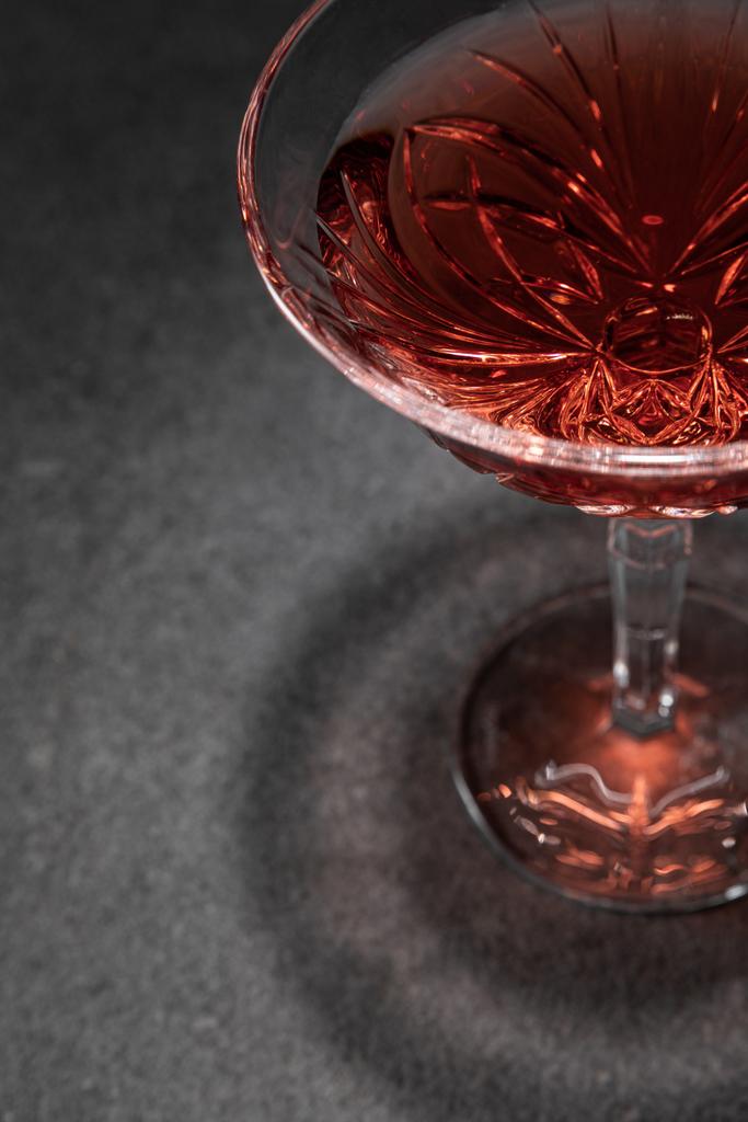 επιλεκτική εστίαση του γυαλιού με κόκκινο κρασί σε γκρίζα επιφάνεια  - Φωτογραφία, εικόνα