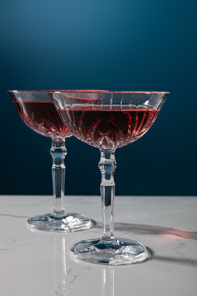 青い大理石の表面に赤ワインのグラスが  - 写真・画像