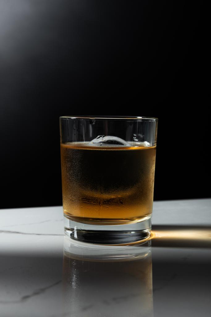 cubo de hielo en vaso de whisky fuerte aislado en negro
  - Foto, imagen
