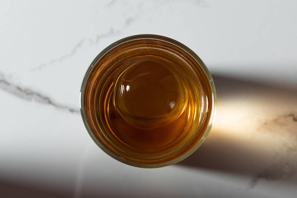 ylhäältä näkymä jääkuution lasi viskiä valkoisella marmoripinnalla
  - Valokuva, kuva