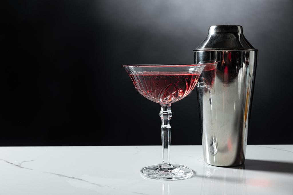 kieliszek czerwonego wina obok shakera na czarno z dymem - Zdjęcie, obraz