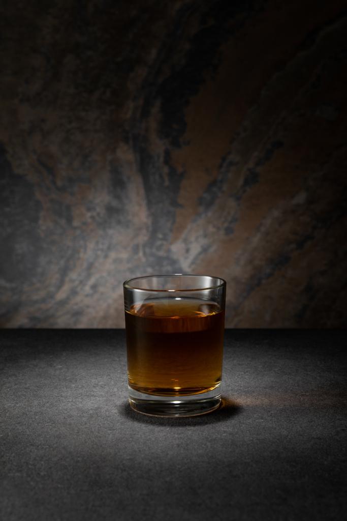 cognac in glas op getextureerde granieten ondergrond  - Foto, afbeelding