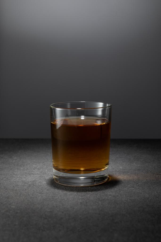 Alkoholgetränk im Glas auf grauem Hintergrund  - Foto, Bild