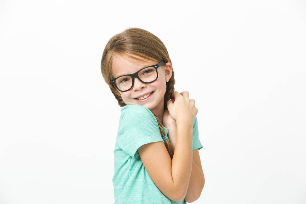 hezká dívka s černými brýlemi a copánky před bílým pozadím ve studiu - Fotografie, Obrázek