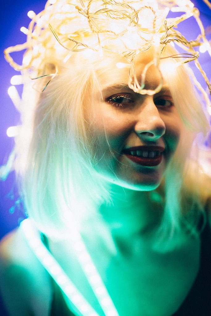 Ritratto ragazza striscia luce nastro LED su sfondo di colore scuro
. - Foto, immagini