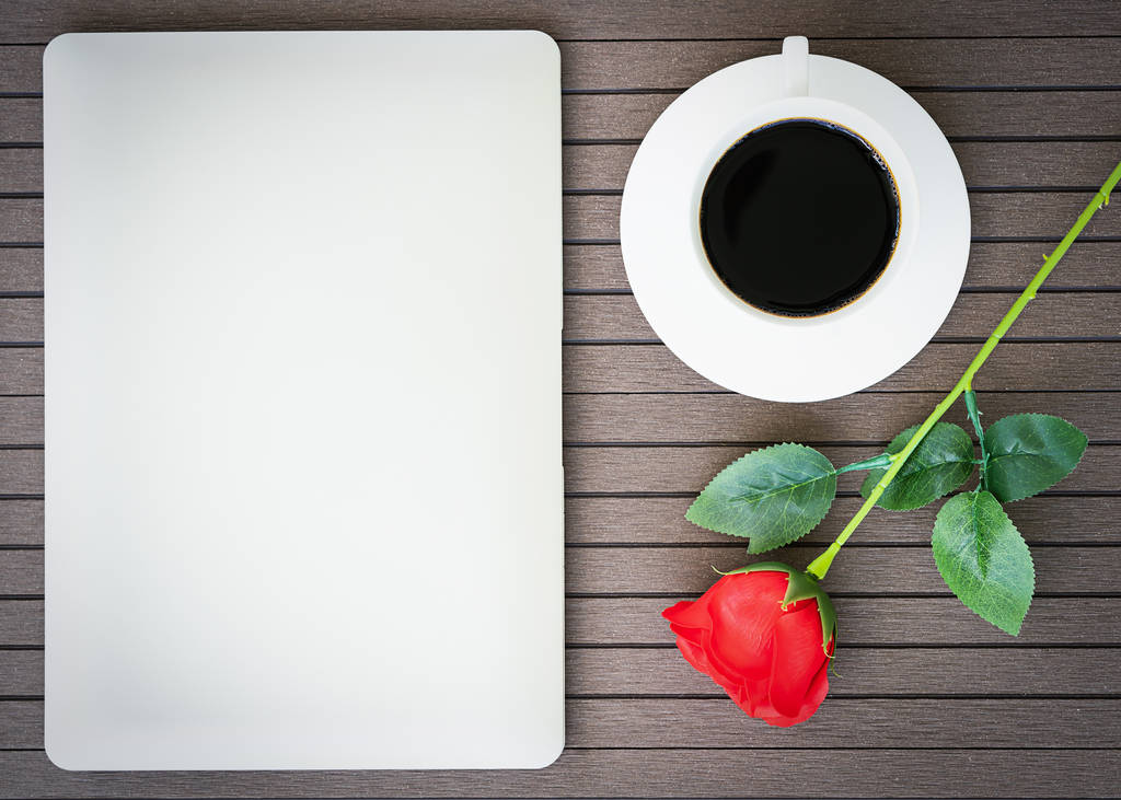 Kaffeezeit-Valentinstag-Konzept, Schreibtisch mit Laptop, Notizbuch, Kaffeetasse, rote Rose - Foto, Bild