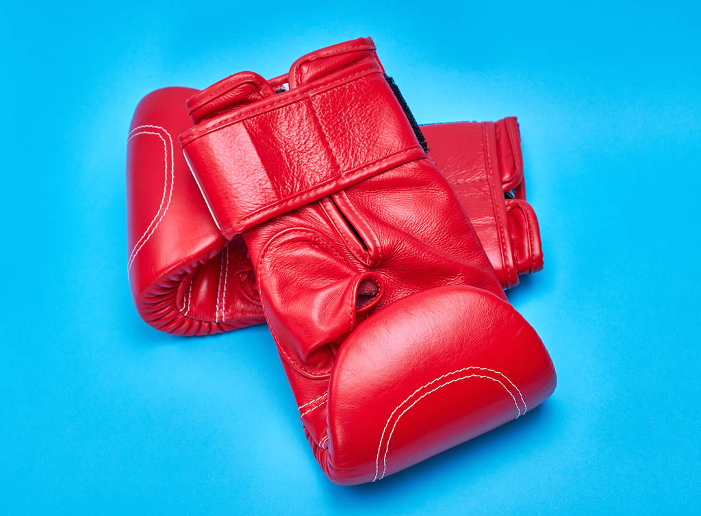 Paar rote Boxhandschuhe aus Leder auf blauem Hintergrund - Foto, Bild
