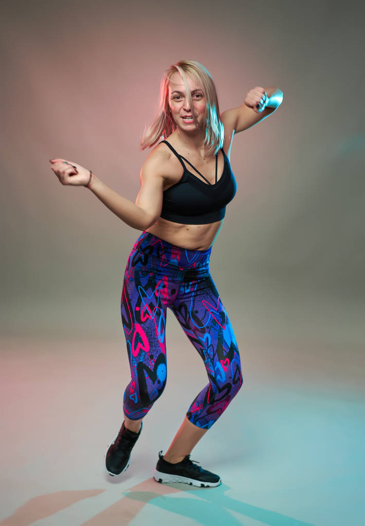Fitness model dělá aerobní cvičení a tanec, studio shot - Fotografie, Obrázek