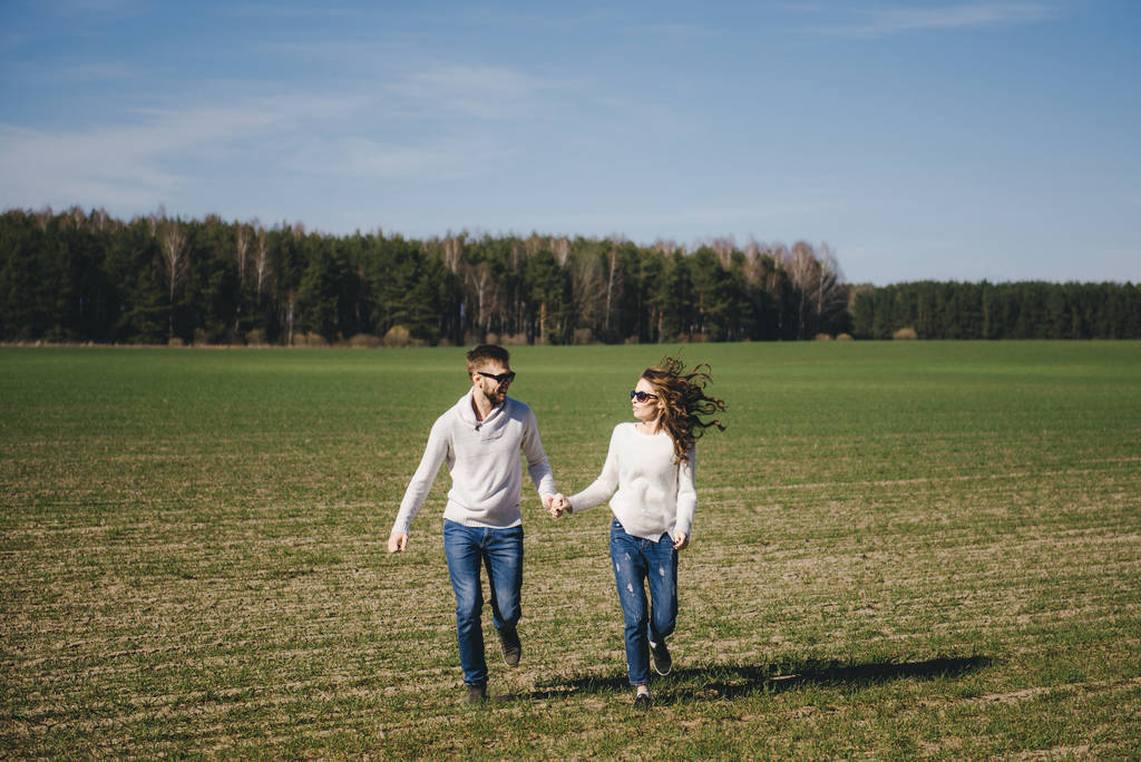 Gelukkig meisje en man rennen en knuffelen op het veld, liefde verhaal reizen concept, selectieve focus - Foto, afbeelding