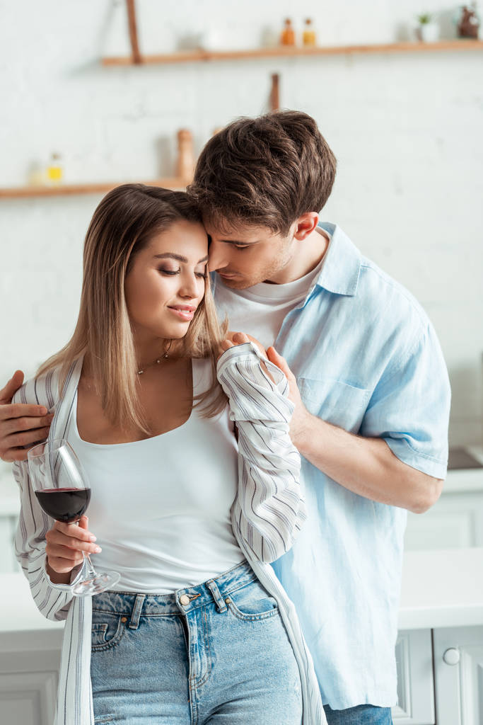 przystojny mężczyzna dotykając atrakcyjne dziewczyna z kieliszek wina  - Zdjęcie, obraz