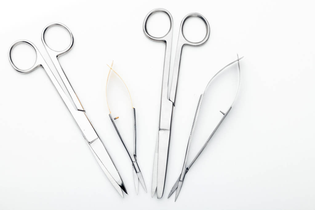 Χαλύβδινα χειρουργικά εργαλεία και εργαστηριακός εξοπλισμός που απομονώνονται σε λευκό φόντο. Επαγγελματικά εργαλεία κλινικής. Ιατρική, χειρουργική, ασθενοφόρο και κτηνίατρος έννοια. Κλείσιμο με μαλακή επιλεκτική εστίαση - Φωτογραφία, εικόνα
