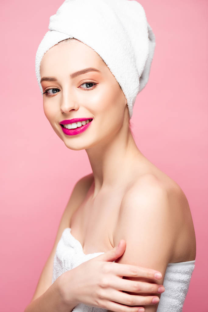 sorrindo jovem mulher em toalha na cabeça isolado em rosa
  - Foto, Imagem