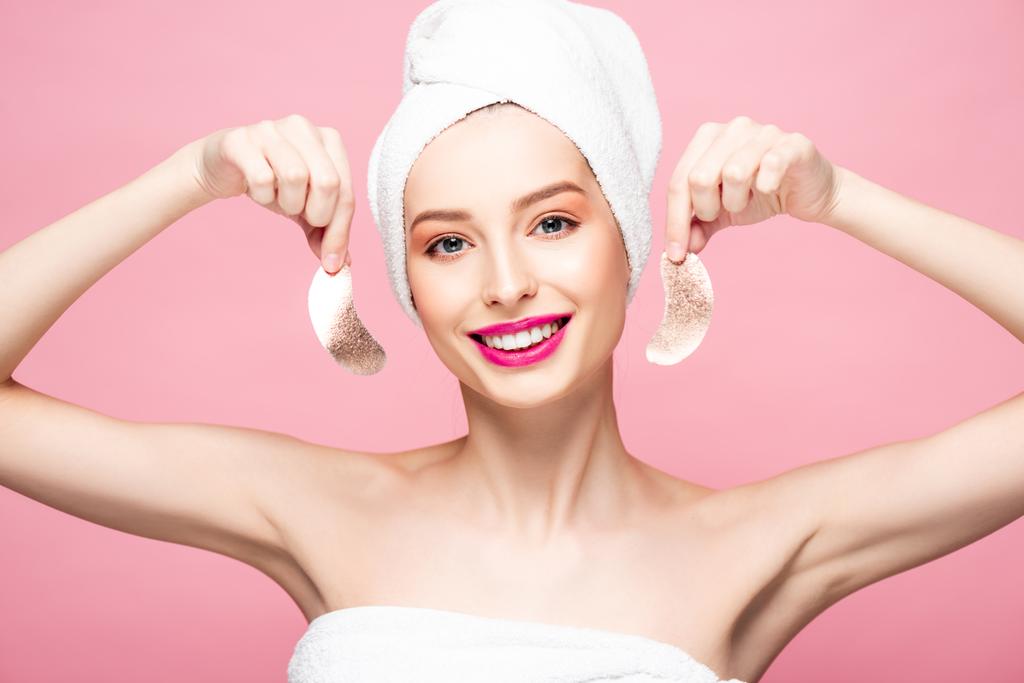 sorridente giovane donna in asciugamano in possesso di macchie oculari isolate su rosa
  - Foto, immagini