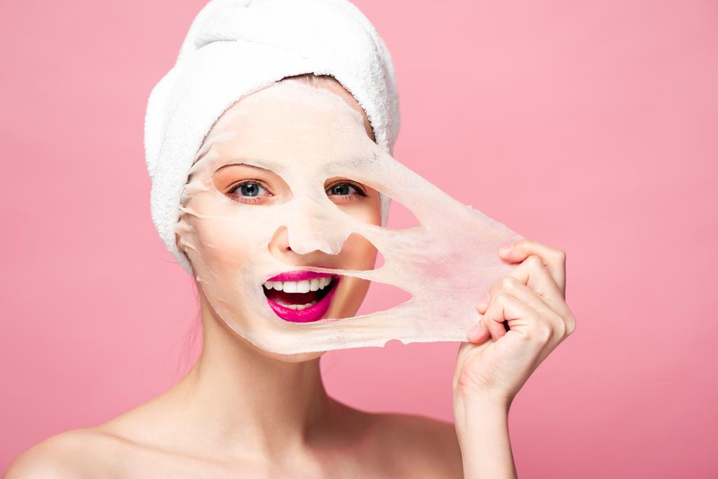meztelen fiatal nő megható arc maszk elszigetelt rózsaszín  - Fotó, kép