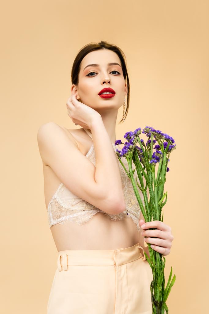 junge hübsche Frau mit Limoniumblüten isoliert auf beige  - Foto, Bild
