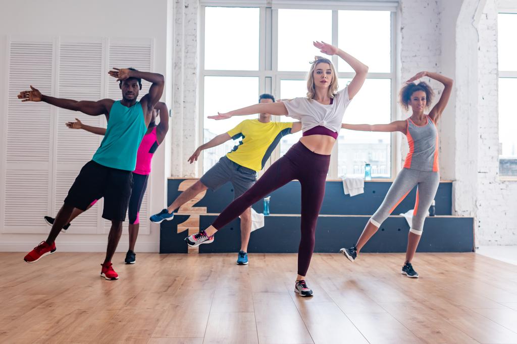 Багатокультурні танцюристи зумба практикують рухи в танцювальній студії
 - Фото, зображення