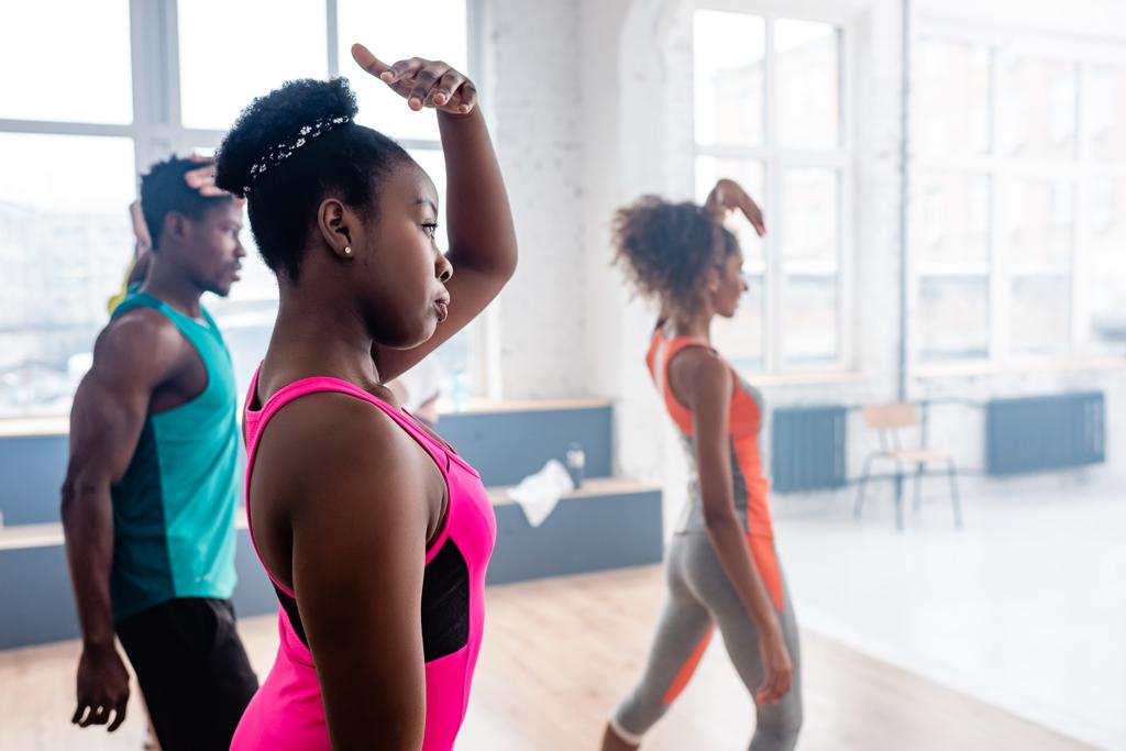 Enfoque selectivo de bailarines afroamericanos practicando zumba con entrenador en estudio de danza
 - Foto, Imagen