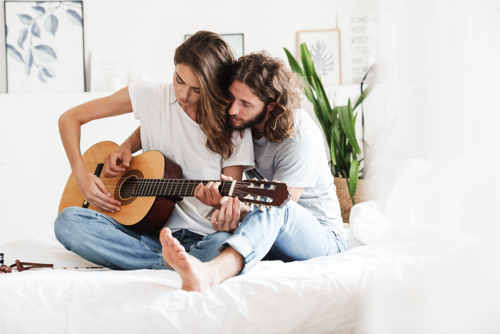Aimer couple à l'intérieur à la maison jouer à la guitare
. - Photo, image