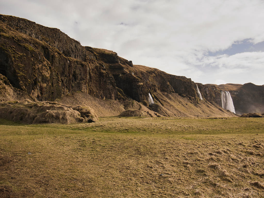 Pradera en una ladera de montaña con varias cascadas en Islandia
 - Foto, imagen